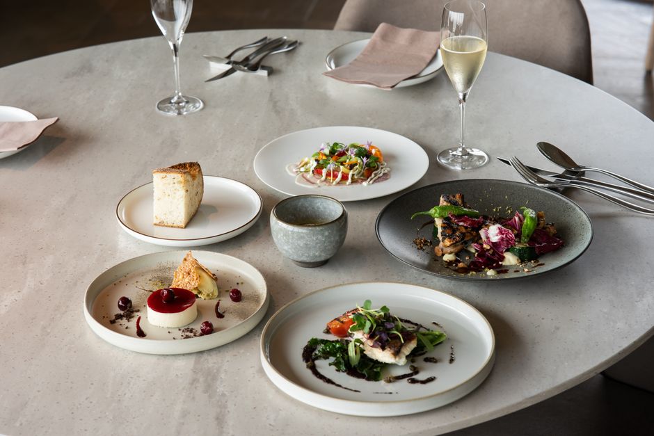 Elegante configuración de cena fina con platos gourmet y vino