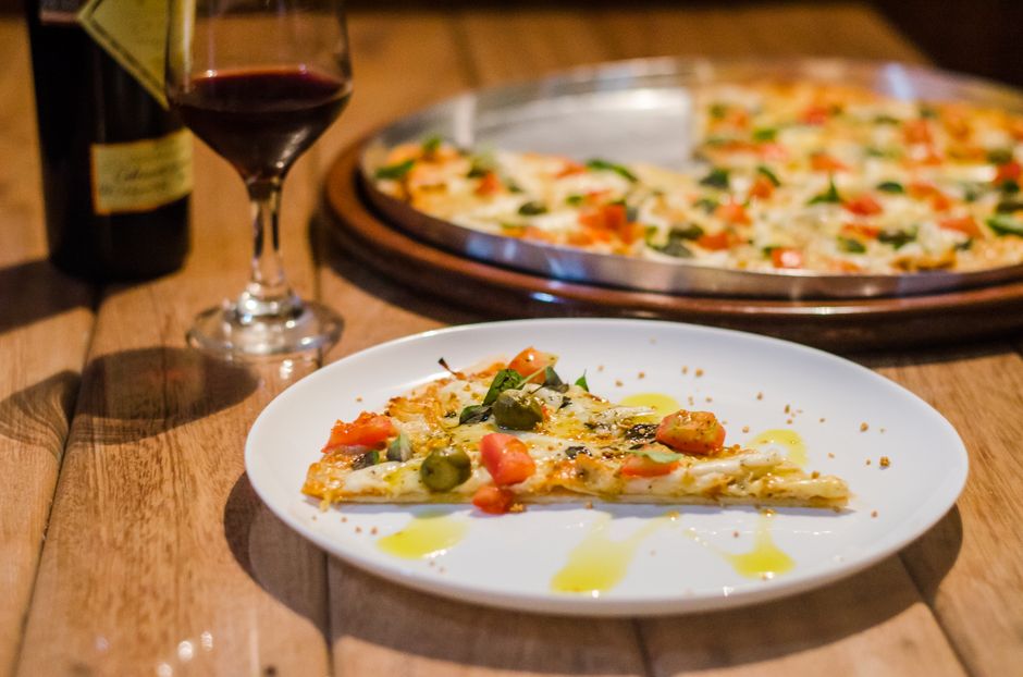 Rebanada de pizza gourmet con vino